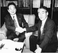 横浜市中区役所で屋代区長と握手する熊川村長（右）
