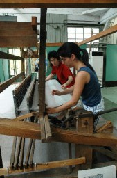 織機に触れながら、織物の歴史を学ぶビエラ市の女性 