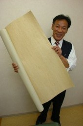 県産の「キビソ」を使った壁紙を手に、「群馬シルクのブランドを確立したい」と話す武井社長
