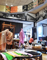 桐生織物会館旧館の１階販売場。天井にはさまざまな織り方による帯などが展示されている
