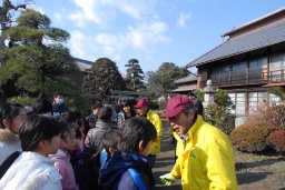 境島小の子どもたちに島村の歴史を説明する田島信孝さん（右） 