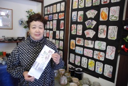 「絵手紙で街めぐり」パンフレットを持つ石井さん＝富岡市富岡の土産店「ふれあいショップ和」 
