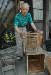 先代が使った蚕種貯蔵用の箱を手にする折茂さん