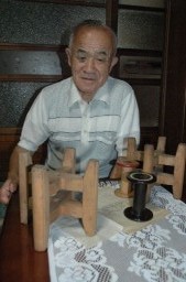 撚糸機の部品を前に下撚りの技法について語る知村さん 