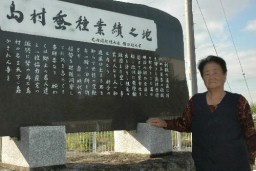 かつて島村蚕種があった場所に建てられた「島村蚕種業績之地」の碑の前に立つ福島さん 