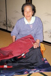 若いころ織り上げたお気に入りの「紬の着物」を手にする中島さん 