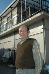 研修生のために建てた家の前に立つ長谷川さん