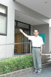 現在ケアセンターとなっている建物の前で、当時の思い出について語る萩原さん