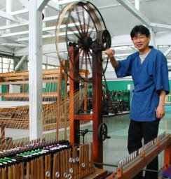 「道具を動かして機械の本当の役割を知ってほしい」と八丁撚糸機を回す長谷川さん