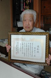県蚕業事務所職員協議会から受けた表彰状を手にする角田さん