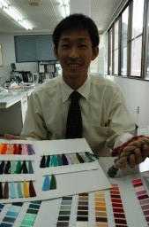 色とりどりのサンプルを手に、糸の特徴を説明する奥田さん