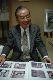 インドネシアで指導した時の写真が収められているアルバムを広げ、蚕種業について語る町田さん 
