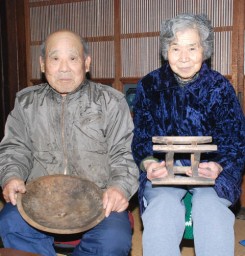 養蚕の道具を手にする茂木忠男さん（左）と妻、たけしさん