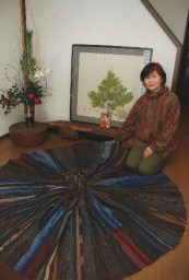 絹糸を使って宇宙をイメージした立体作品を前にする豊田さん