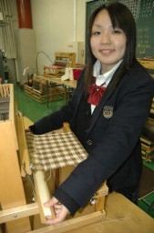 教室で卓上織機を手にする芝田さん
