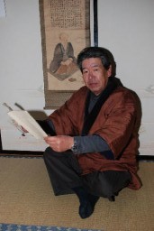 「岩崎竹松」の肖像を描いた掛け軸と岩崎さん