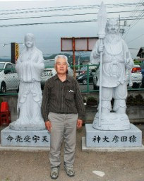 猿田彦大神と天宇受売命の夫婦像の前に立つ大島さん