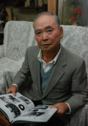 「大泉高校八十年史」を見ながら養蚕を指導した当時を振り返る富田さん